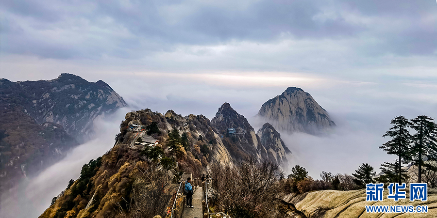 12月10日，游人步入华山苍龙岭，眺望北峰。