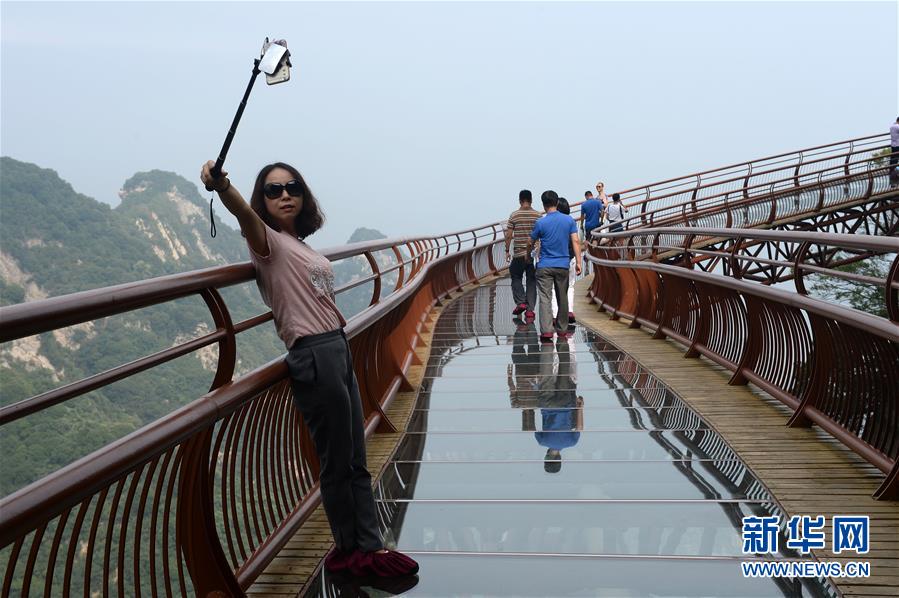 　　7月15日，游客在少华山玻璃栈道自拍留影。