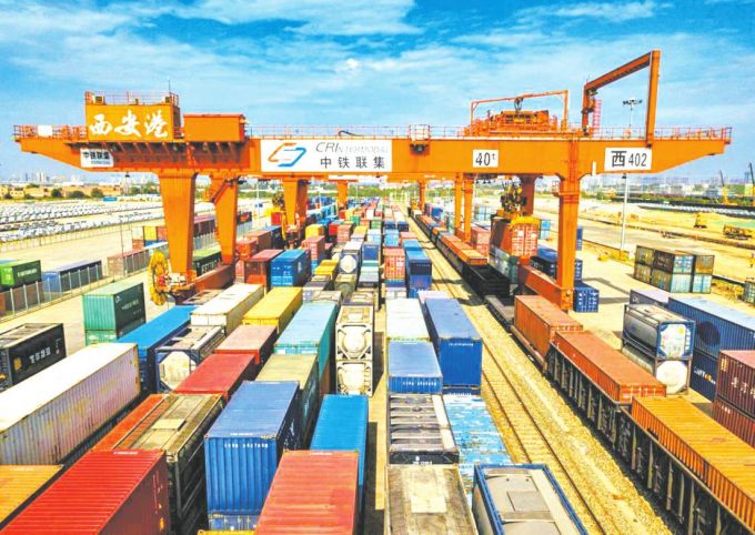 西安港集装箱铁路装卸区一片繁忙景象。西安港是全国最大的国际内陆枢纽港，国内外货物在这里集散、中转、分拨。